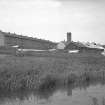 View from SW showing W front of works with flats on left and canal in foreground