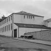 View from SSE showing SW front and part of SE front of factory with numbers 6-10 Society Street in background