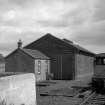 View from W showing SSW front and part of WNW front of office with goods shed in background and wagon on right