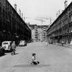 Glasgow, Hutchesontown.
View of Area C under construction from South along Sandyfaulds Square with tenements and small boy in foreground.