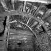Interior of cruck-framed byre showing roof detail, roof groundwork and cruck-frame in foreground composed of re-used ships timbers; The Buaile, Ramscraigs.