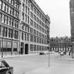 View from N showing WNW front of factory with part of warehouse in foreground and 117 Ingram Street in background