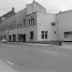 View from W showing NNW front of stables with works in background