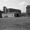 View from SE showing SSW and ESE fronts of numbers 89-93 French Street with part of Barrowfield Weaving Factory on right and Barrowfield Spinning Factory in background