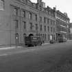View from S showing ESE front of rubber works with warehouse in background
