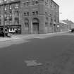 View from W showing WNW and SSW fronts of depot with part of tenements on left