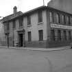 View from ENE showing NNE and ESE fronts of office block with engineering shop in background