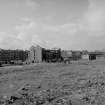 Distant view from NE showing remains of cotton mill with work on right and tenements on left