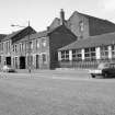 View from ENE showing ESE front (Admiral Street front) of works with part of school in foreground