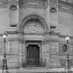 Detail of entrance on Bristo Square elevation with two ornamental street lamps on either side of doorway
