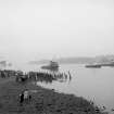 View looking SE showing QE II on River Clyde approaching Bowling with remains of pier in foreground