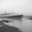 View looking SE showing QE II on River Clyde approaching Bowling with remains of pier in foreground