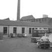 View from SE showing part of ESE front of E block of mills with chimney of refuse disposal works in background