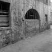 View from S showing bricked up arched doorway on ESE front