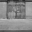 View from WNW showing large ornamental doorway of high single storey block. Rowan and Co Ltd, Elliot Street, Glasgow.