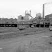 General view from S showing S front of old washer plant (right) with coal elevator shed and hopper, headgear, dense medium plant, pithead building and south elevator conveyor system on left