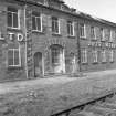 View from S showing bricked up main entrance on SSE front of calender shop