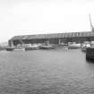 View from NNW showing hopper barges in Camperdown Dock with E transit shed of The Queen Elizabeth Wharf in background