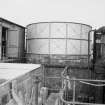 View from WSW showing curved WSW front of S acid tank with part of hut on left and water tank on right