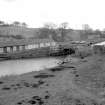 View from SSW showing S front of cottages with bridge and landing stage (used by the Fairly Queen until 1939) on right