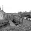 View from WNW showing N front of overflow with W front of cottages on left and bridge in background