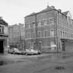 View from N showing NNE and WNW fronts of N block of stables with part of number 90 Tobago Street in foreground