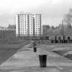 View looking WNW along S pier of harbour with tower block in background