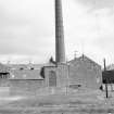 View from WSW showing chimney and WSW front of weaving sheds and engine house