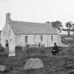 Lismore, St Moluag's Cathedral.
General view from North-East with man bending down in graveyard.