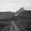 Distant view of the old inn, with the farmstead to the left of the photograph, with the Sgurr of Eigg in the background

