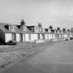 View from NNW showing row of one storey and attic cottages, modernised by additional dormer windows