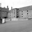 View from SE showing SSW and ESE fronts of E bay wing with castellated hoist block and central silo block