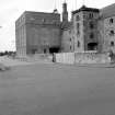 View from SE showing SSW and ESE fronts of E castellated hoist block and central silo block, with drying kiln vents visible