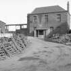 View from S showing ESE, SSW and WSW fronts of gatehouse with part of tank in foreground