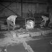 Interior
View showing men pouring iron into moulds