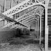 Interior.
View of cast-iron roof trusses and columns with gothic shaped wooden infills in central section of top floor of main building.
Digital image of A 38495