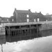 View from NNE showing S lock gate at entrance to Albert Dock with workshops and part of pumping station in background