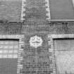 Digital image of a detail of typical round cast-iron tie-plate in exterior SE wall of former Mule Mill (building B6)