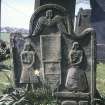 View of gravestone depicting male and female figures.