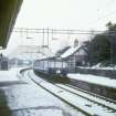 View from WSW showing Glasgow - Neilston train entering station with footbridge in background