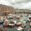 View from NNE showing boats moored in harbour with NNW and ENE fronts of Harbour Terrace in background