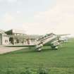 View from SSE showing D.H. Dragon Rapide aircraft outside airfield blocks