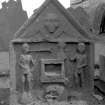General view of gravestone commemorating 'J.C'. Winged soul, Two figures with trumpet and hourglass, deathbed and skull below.
Digital image of B 42930/32