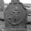 General view of gravestone commemorating John King, 1764 in the churchyard of Boyndie Old Parish Church. Rosette and angel with trumpet with scroll emerging.

