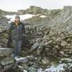 Mr Matthew Ritchie in the stone-walled hut (possible mess hut) at the OS Colby Camp on Ben Lawers. View from S.