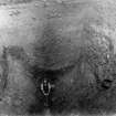 Excavation photograph showing workman indicating scale in excavated trench, taken during the James Curle excavation 1905-1909.