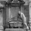 Scanned image of Perth, Greyfriars Burial Ground.
View of the monument to the Rev. George Kennedy, 1835. A large mural monument with broken curved pediment with central armorial sheild. The lower part of the monument shows a veiled woman bent in the attitude of mourning over a sarcophagus. She appears to be life-size.