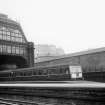 Scanned image of view from platform looking east to Lothian Road showing part of roof, train and Castle in background