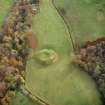 Oblique aerial view centred on the remains of the motte with the church and burial-ground adjacent, taken from the NW.