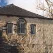 Detail of arched window flanked by two smaller windows.